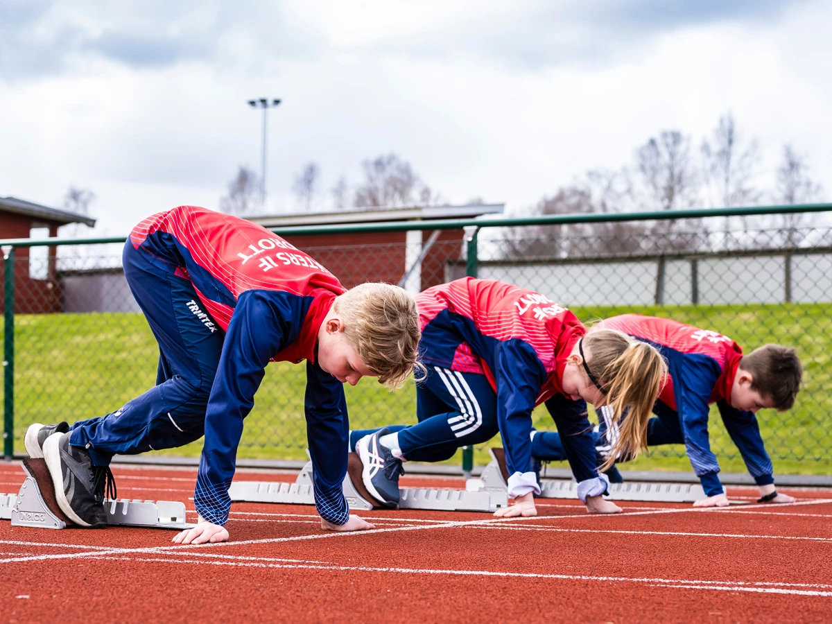 Tre barn står redo för start på löparbanan