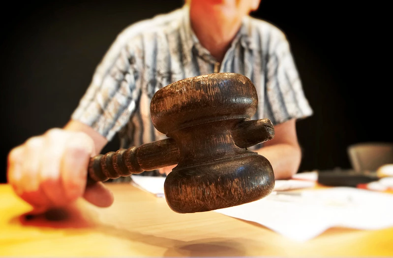 man slår med klubba på ett skrivbord