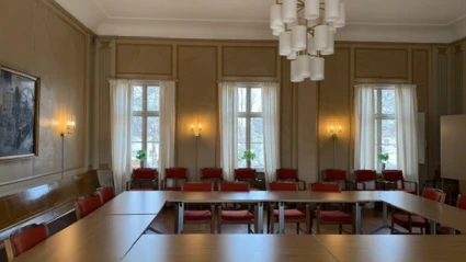 Sammanträdesrummet fullmäktigesalen med bord och stolar.