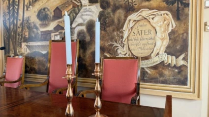 Sammanträdesrummet fullmäktigesalens presidiebord med ljusstakar.