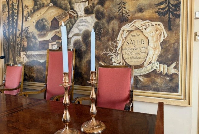 Sammanträdesrummet fullmäktigesalens presidiebord med ljusstakar.