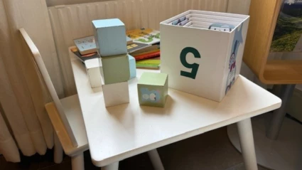 Lekhörna med bord, stolar, böcker och klossar.