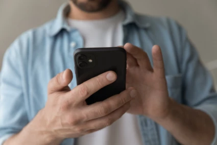 En man som skrollar i sin mobil