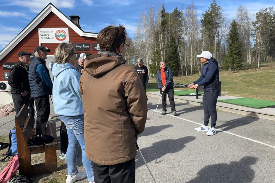 Deltagare i Seniorkul tittar på en golfinstruktör