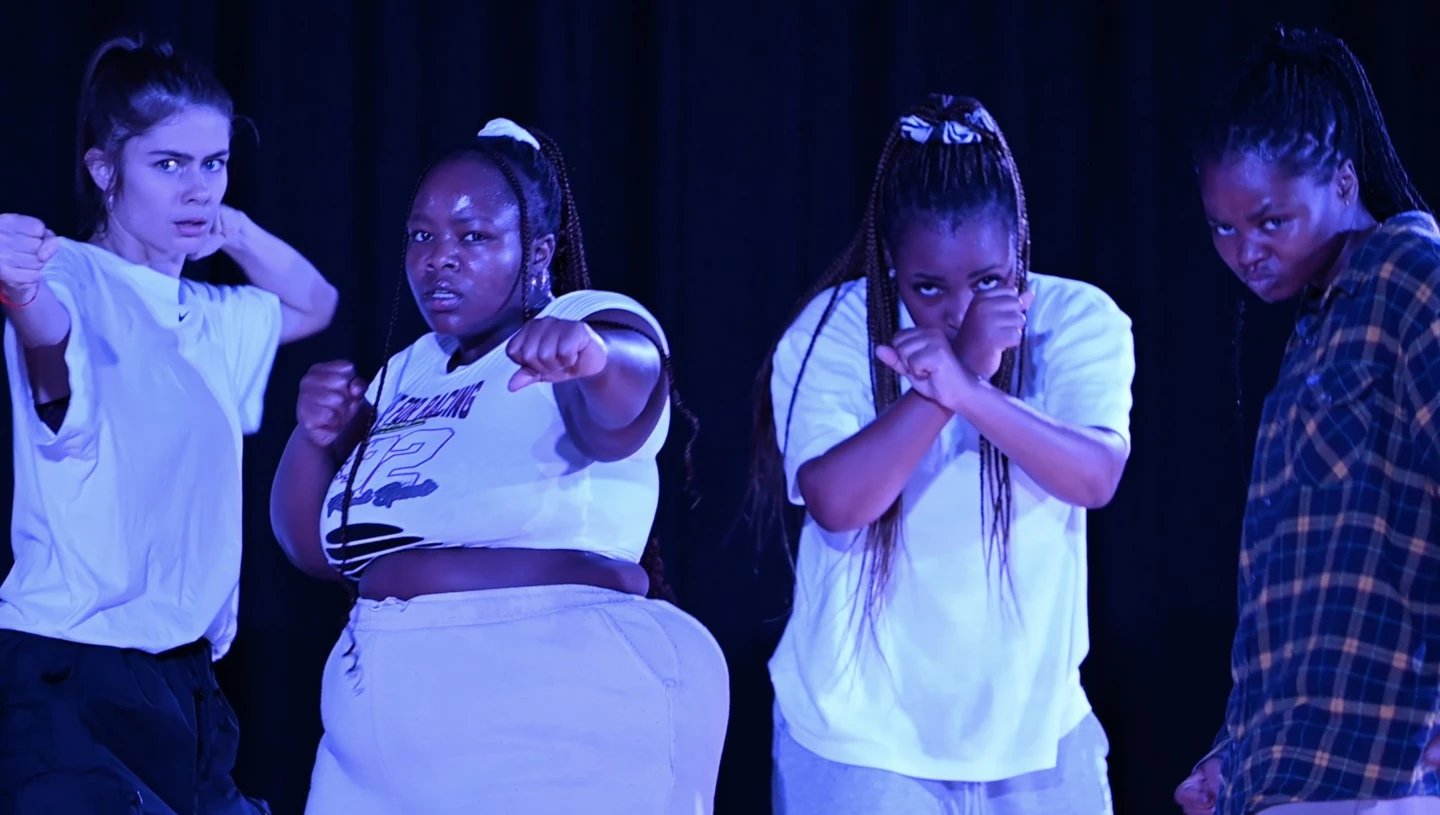 Scenisk bild på 4 tjejer med kraftfulla ansiktsuttryck.