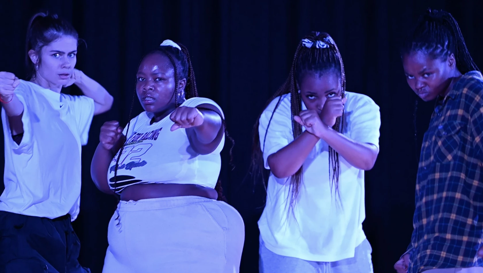 Scenisk bild på 4 tjejer med kraftfulla ansiktsuttryck.