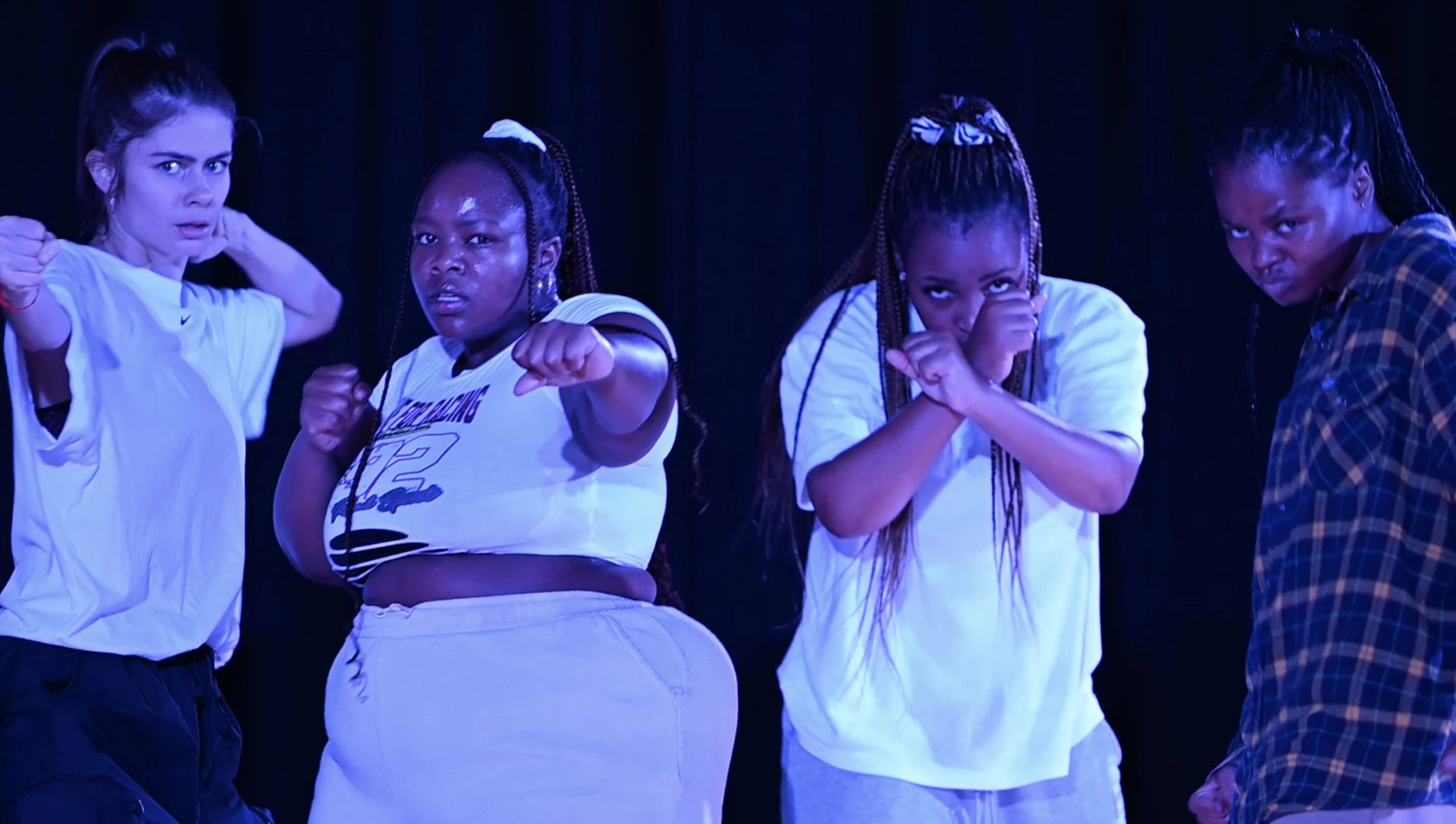 Scenisk bild på 4 tjejer med kraftfulla ansiktsuttryck.