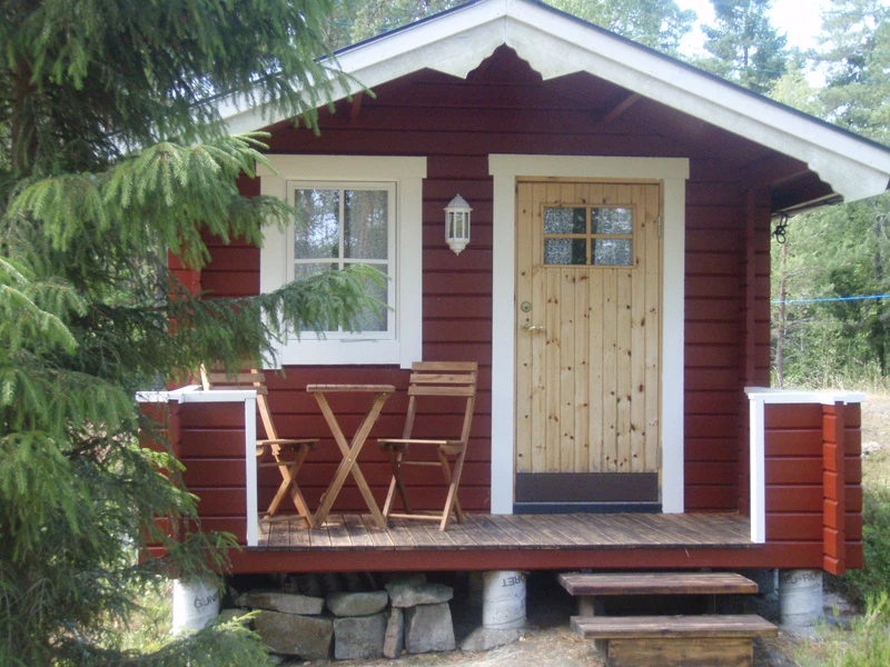 Fristående mindre bostadshus på villatomt, till exempel attefallshus, i bostadsmiljö med trädgård.