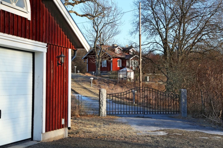 Ett garage vid sidan om ett rött hus