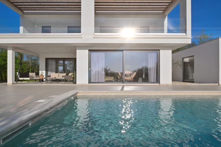 Pool i trädgård vid villahus med altan och utemiljö