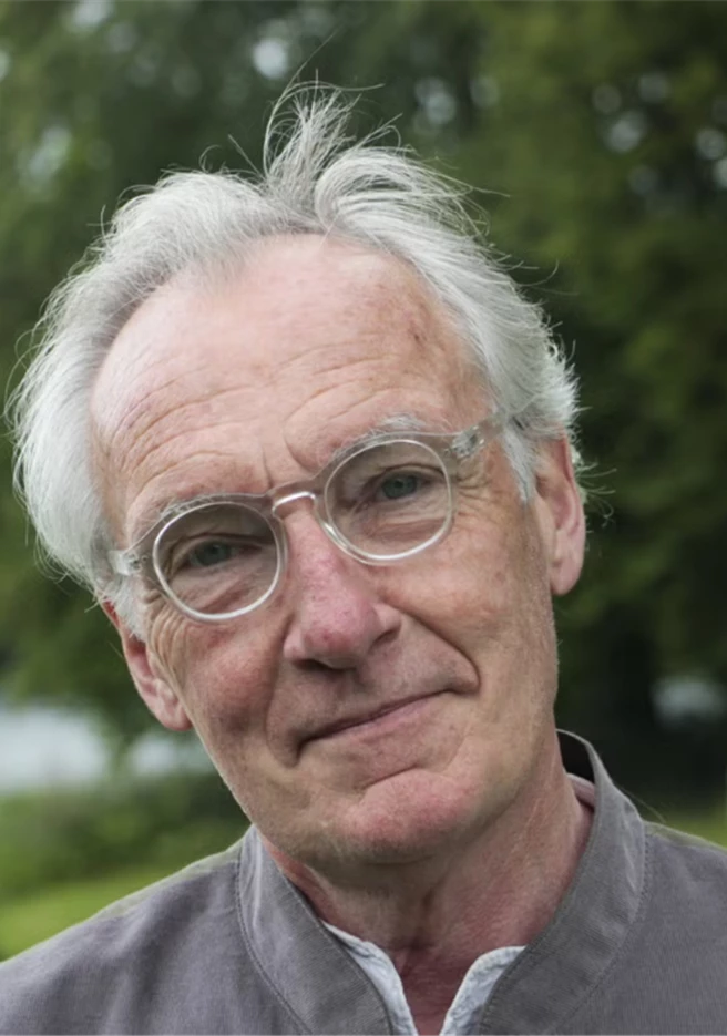 Fotografi på Bengt Söderhäll. Bengt står utomhus med träd i bakgrunden. Grå skjorta och glasögon.
