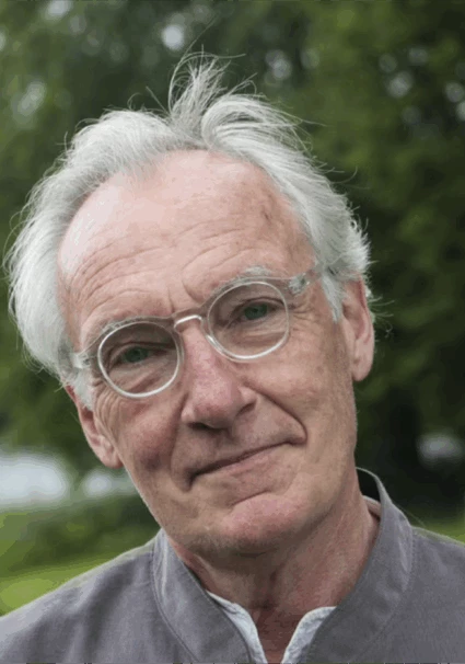 Fotografi på Bengt Söderhäll. Bengt står utomhus med träd i bakgrunden. Grå skjorta och glasögon.