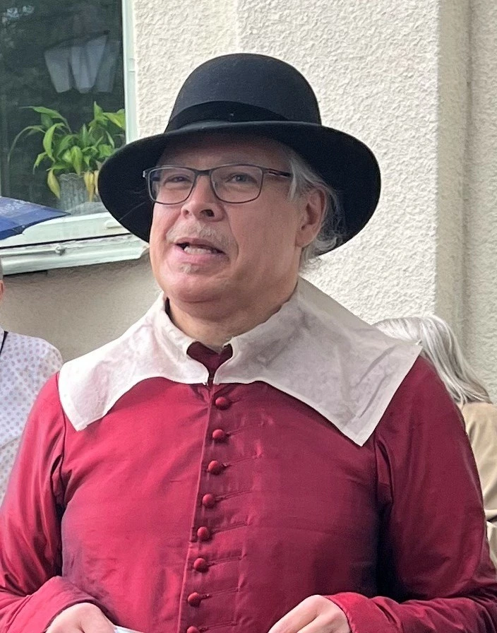 bild föreställande historisk person, Wellam Silentz med röd dräkt, vit krage och svart hatt.