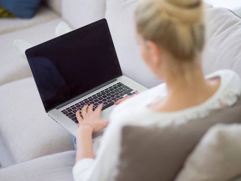 kvinna skriver på laptop