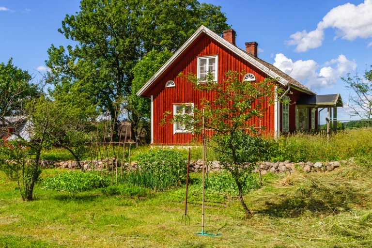 ett rött hus på en grön kulle