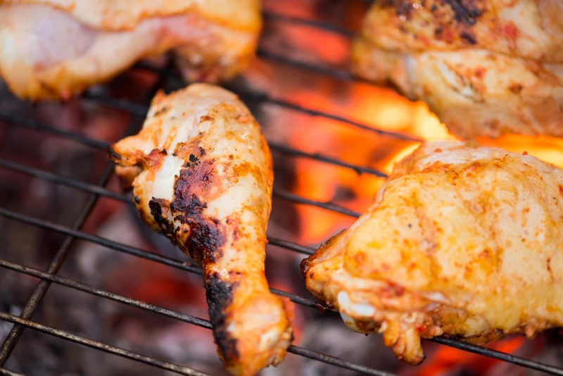 Kycklingklubbor på en kolgrill