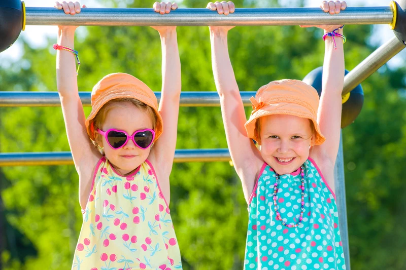 Två små flickor hänger i en klätterställning