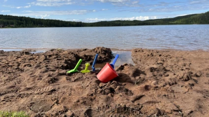Hink och spade vid strand.