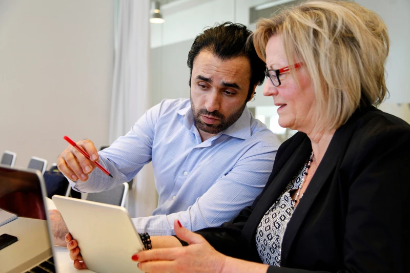 två personer tittar på en läsplatta