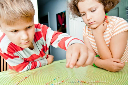 två barn som spelar plockepinn