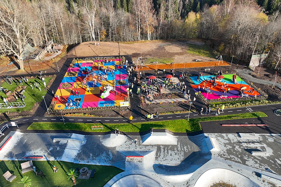 Drönarbild över Pep Park Säter med färgglada lekytor, lekutrustning och många besökare som samlats i parken.