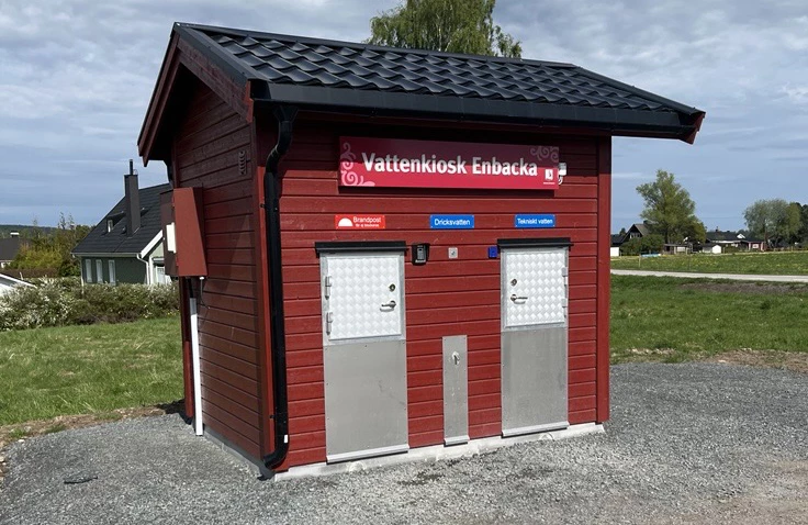 ett rött litet hus med skylten Vattenkiosk